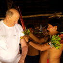 Daví Kopenawa attaches macaw feathers to King Harald&#146;s arm just prior to departure. This is held to be a special badge of honour.  (Photo: Rainforest Foundation Norway / ISA Brazil)